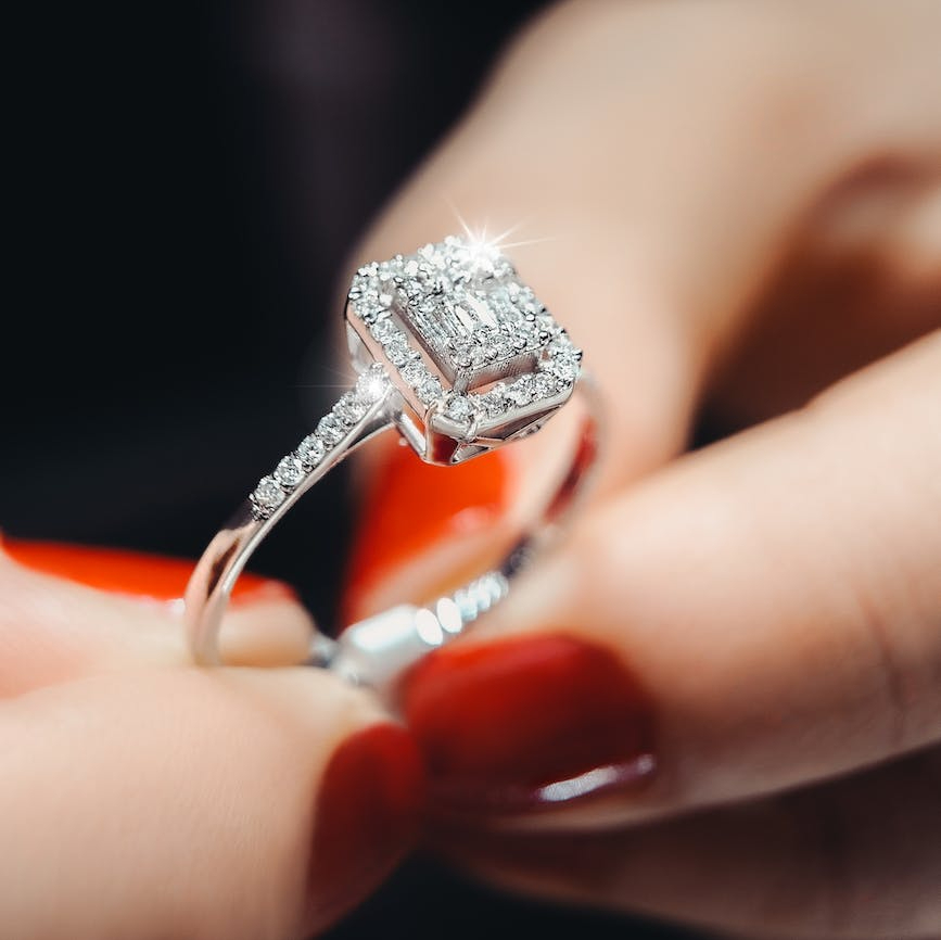 close up photo of person holding diamond ring